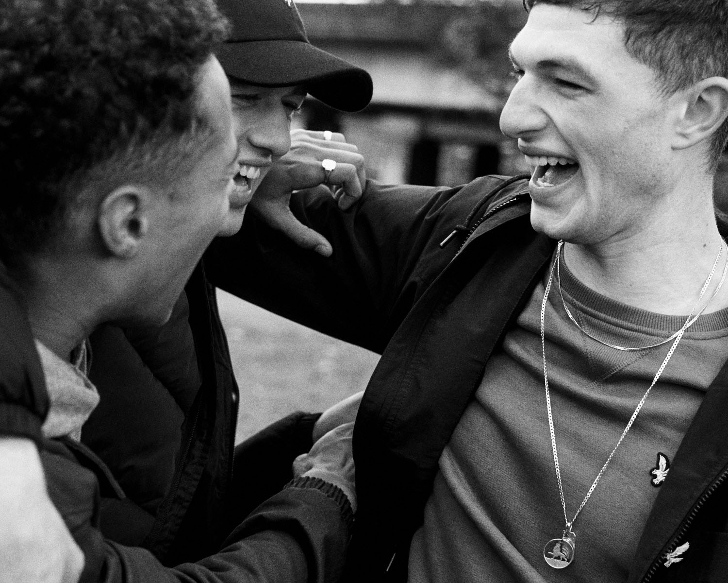B/W,3 Lads  hug and laugh by lifestyle photographer Tim Cole