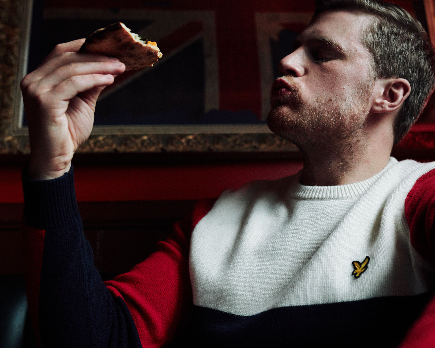 Lad  eats pizza In pub by lifestyle photographer Tim Cole