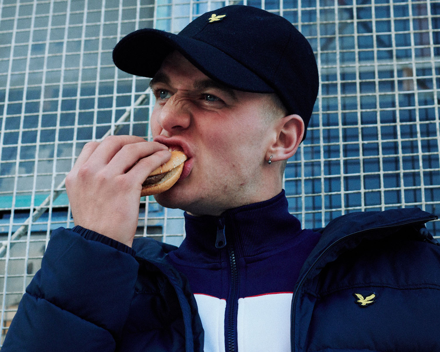 Lad in, eats burger by lifestyle photographer Tim Cole