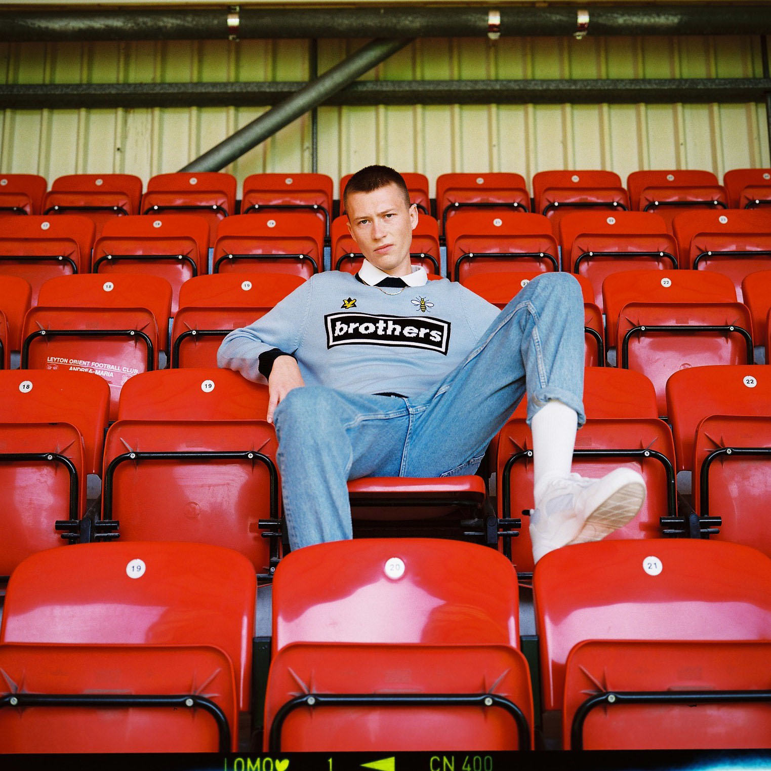 Lad  on red stadium chair by lifestyle photographer Tim Cole 
