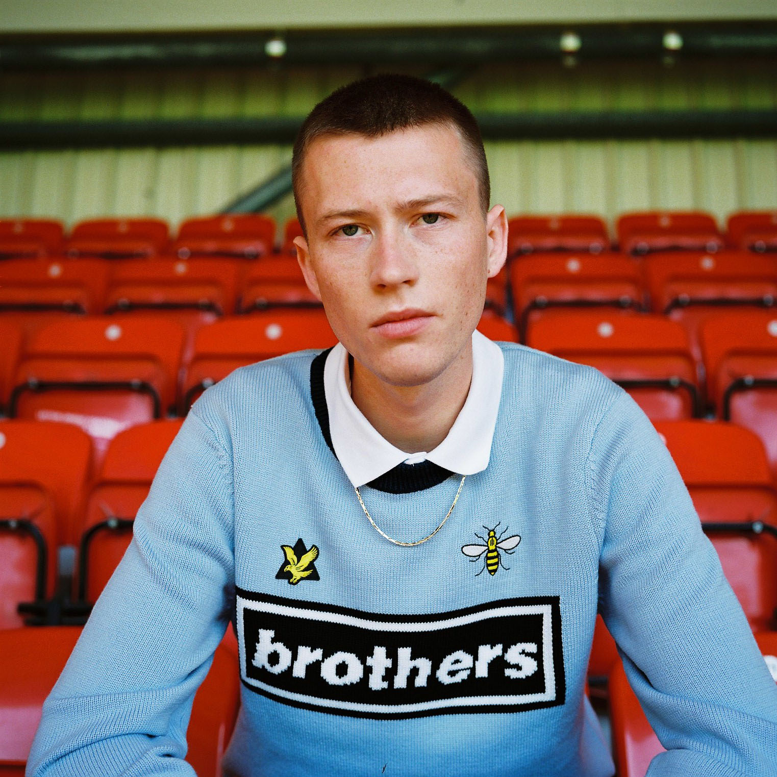 Lad sits in red stadium chair by lifestyle photographer Tim Cole 