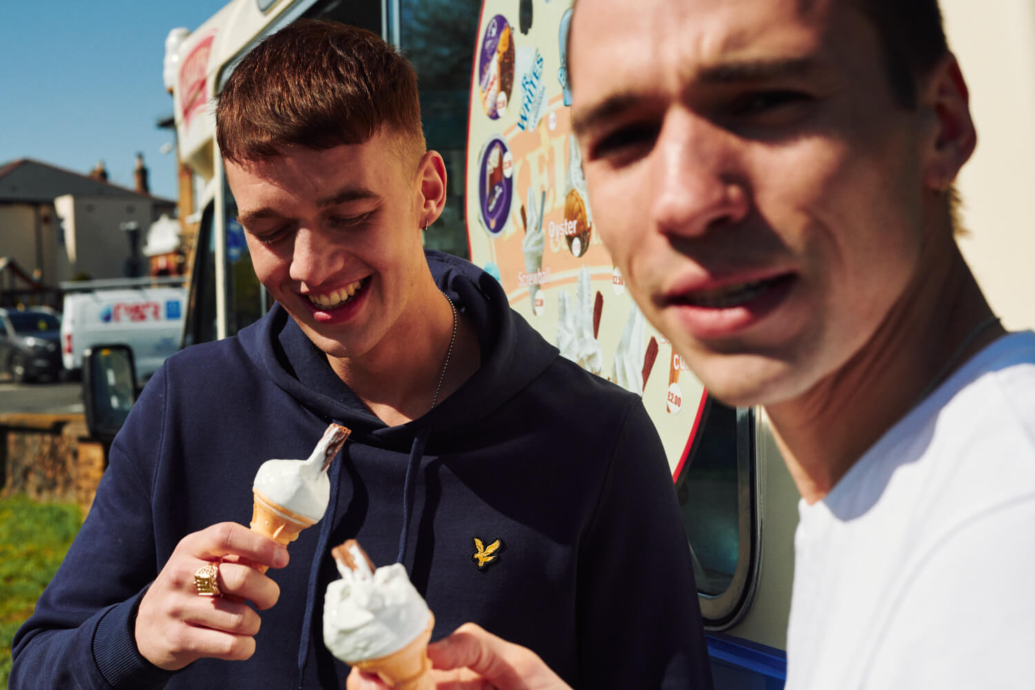 Two lads joke  next to an ice cream van in Bexleyheath 