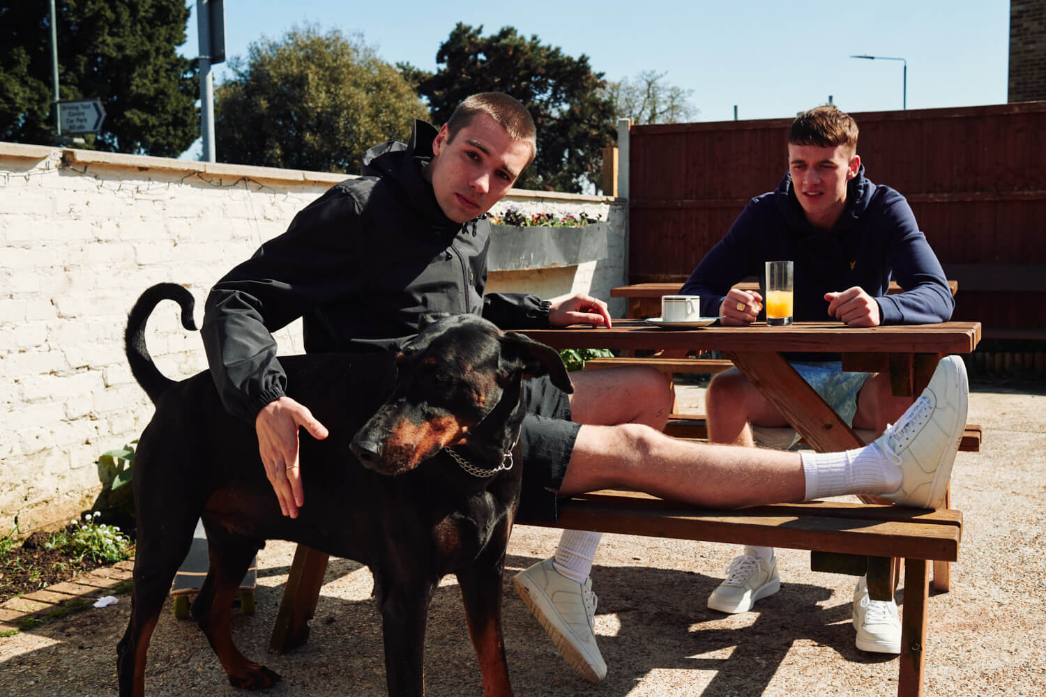 Two lads  in beer garden,  dog by lifestyle photographer Tim Cole 