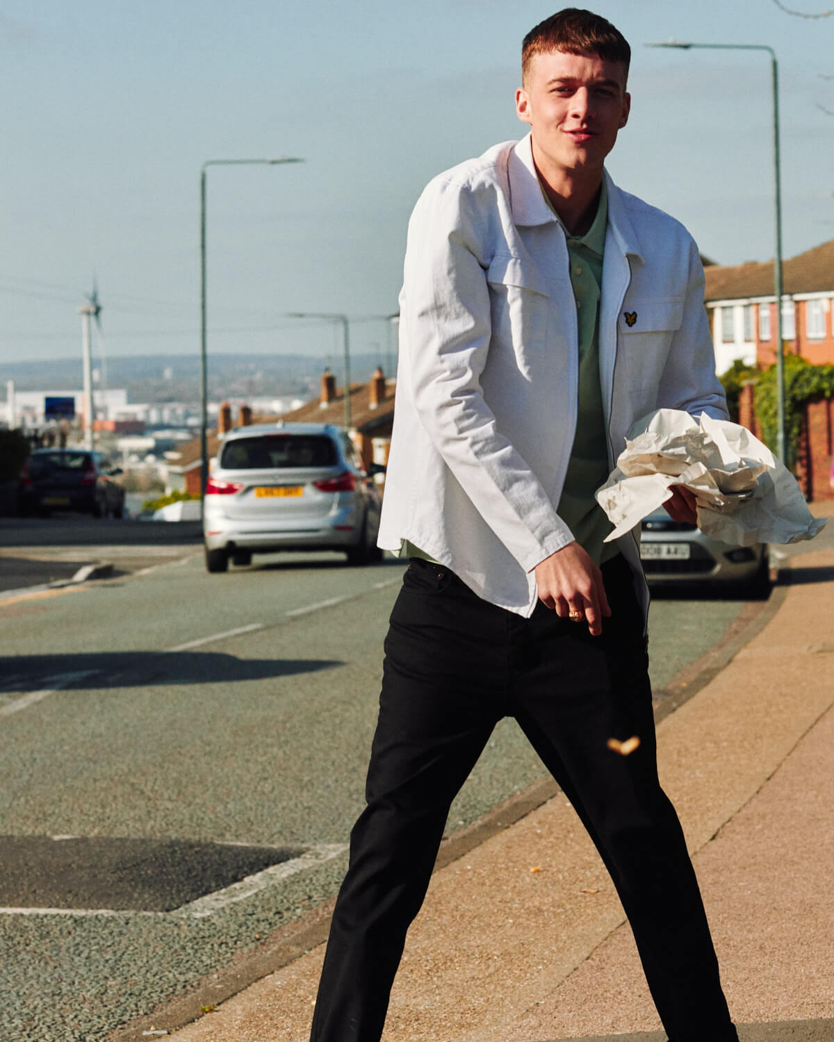 Lad in  eats chips in the street, by lifestyle photographer
