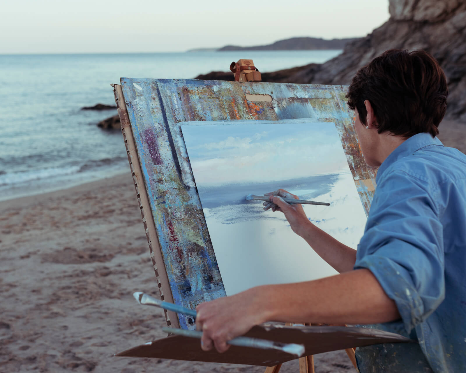 artist paints a picture by the sea by lifestyle photographer cb