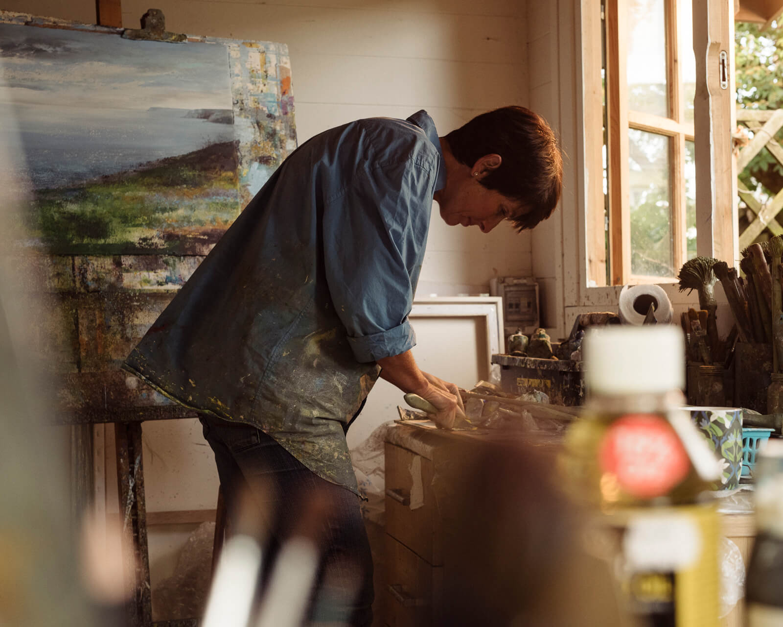 artist paints  in her studio  by lifestyle photographer Tim Cole