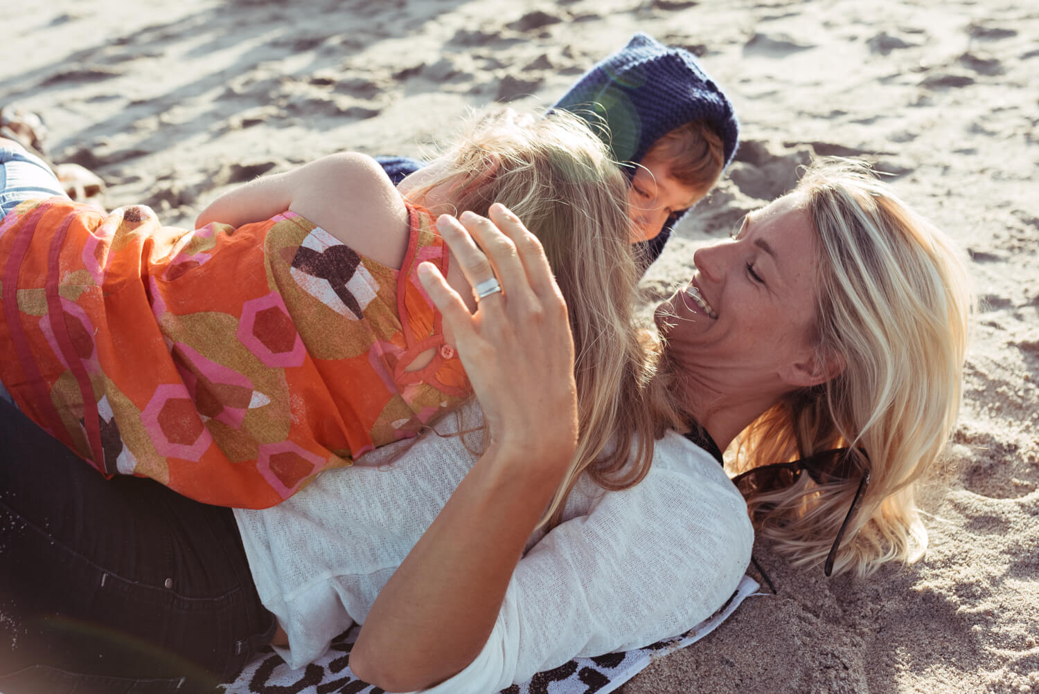 Mother two kid, on sandy beach by lifestyle photographer Tim Cole