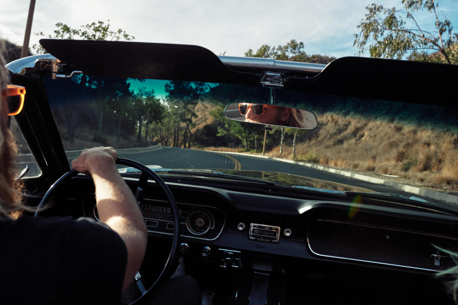 Blonde  hipster on open road by lifestyle photographer Tim Cole
