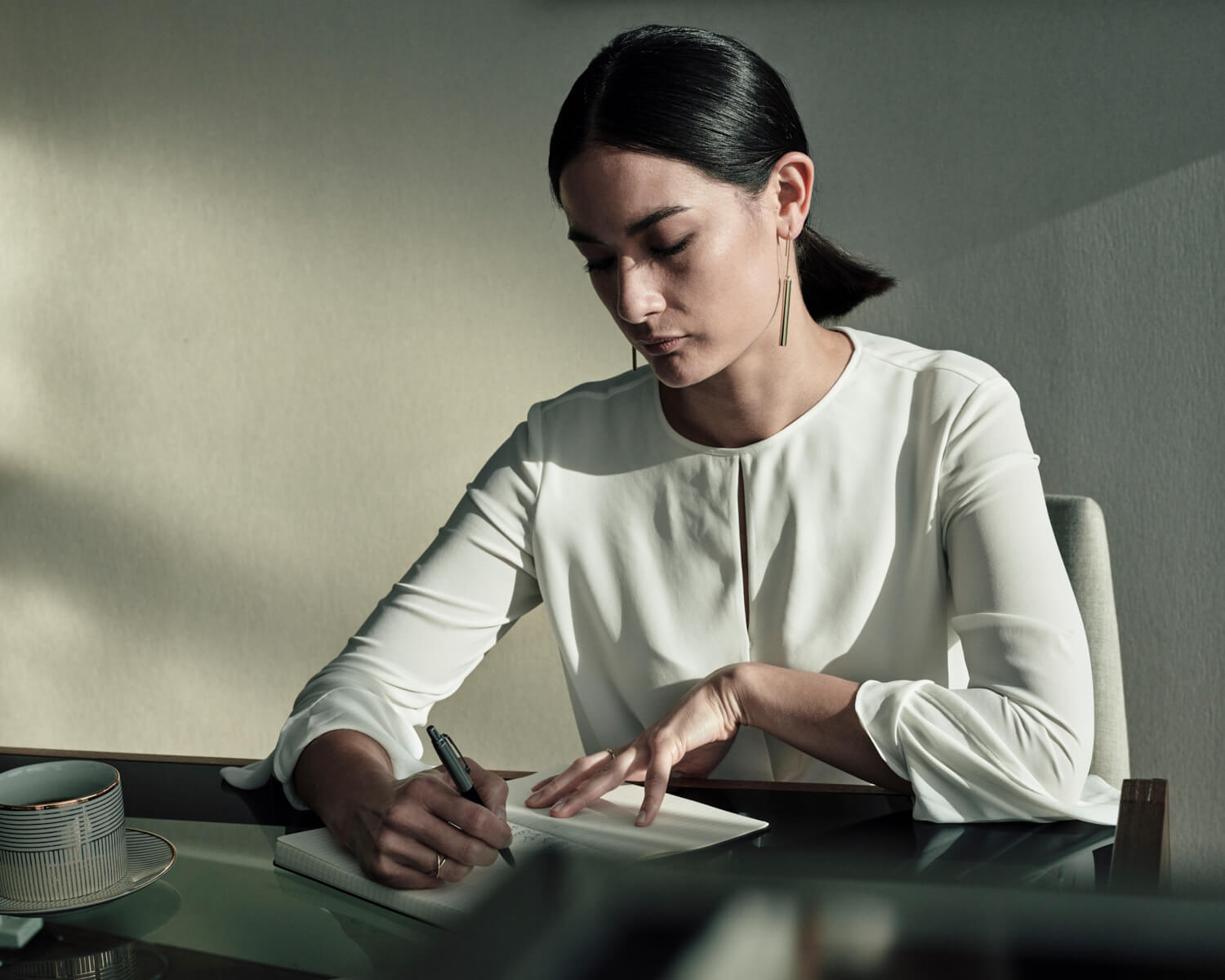 Woman, at home desk, by lifestyle photographer Tim Cole
