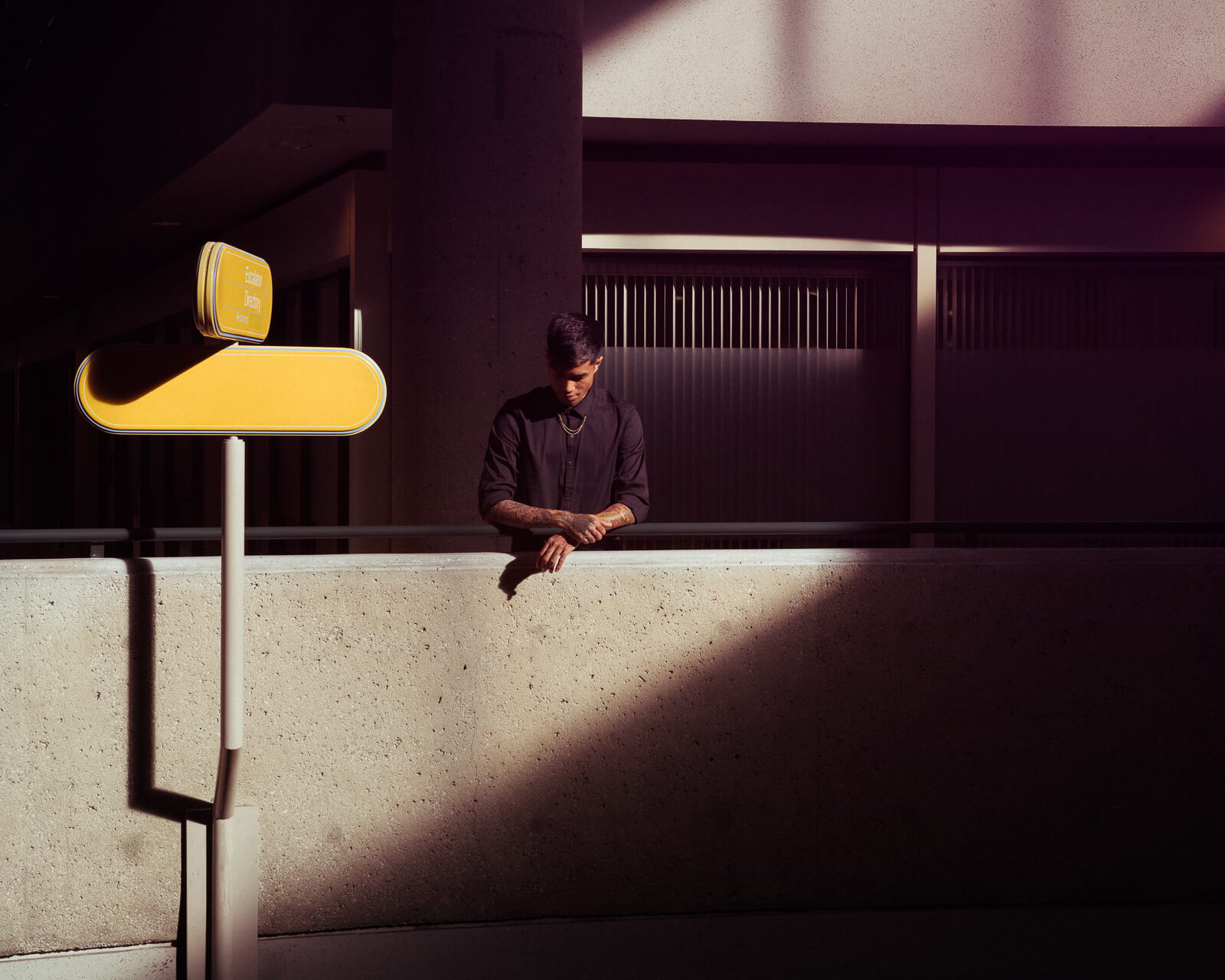 Guy in black,  hotel atrium by lifestyle photographer Tim Cole